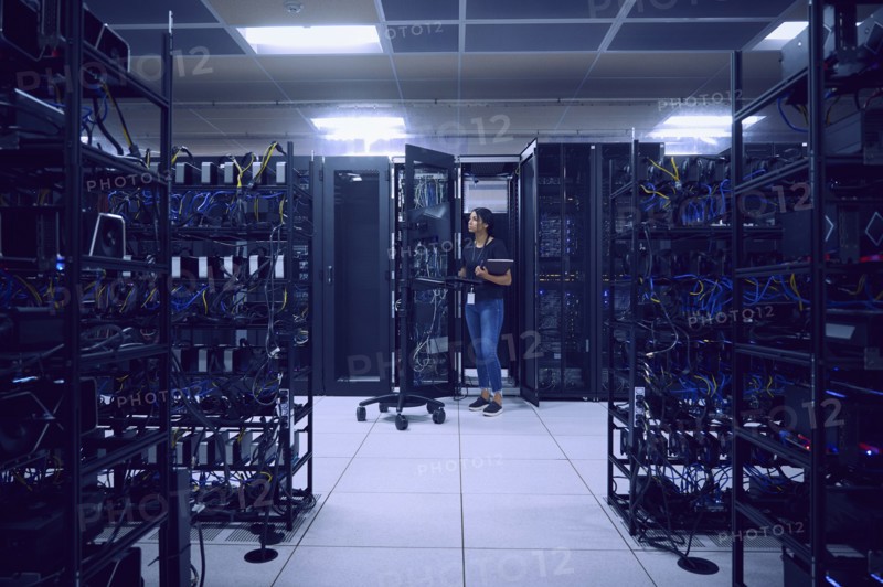Female technician working in server room
