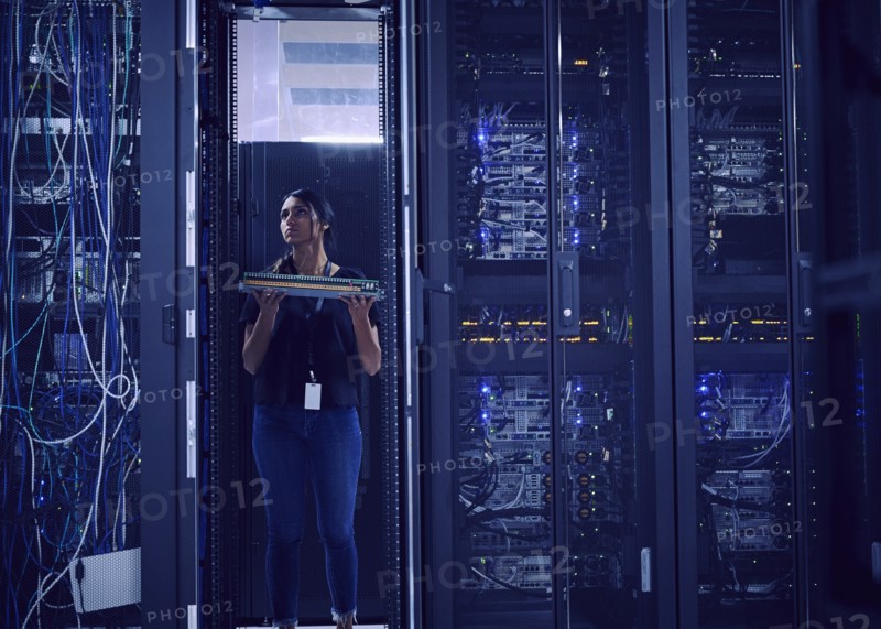 Female technician working in server room