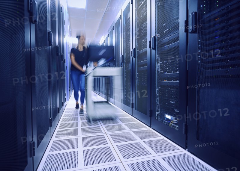 Female technician pushing cart in server room