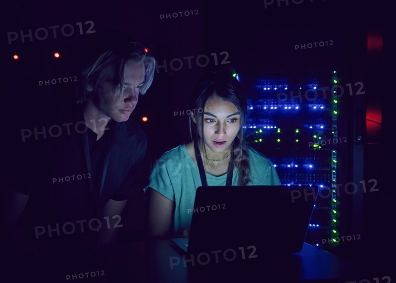 Technicians using laptop in server room