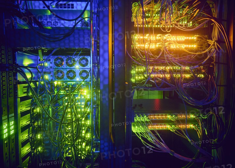 Illuminated servers and computer cables in server room