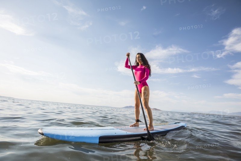 Woman standing on paddleboard in lake