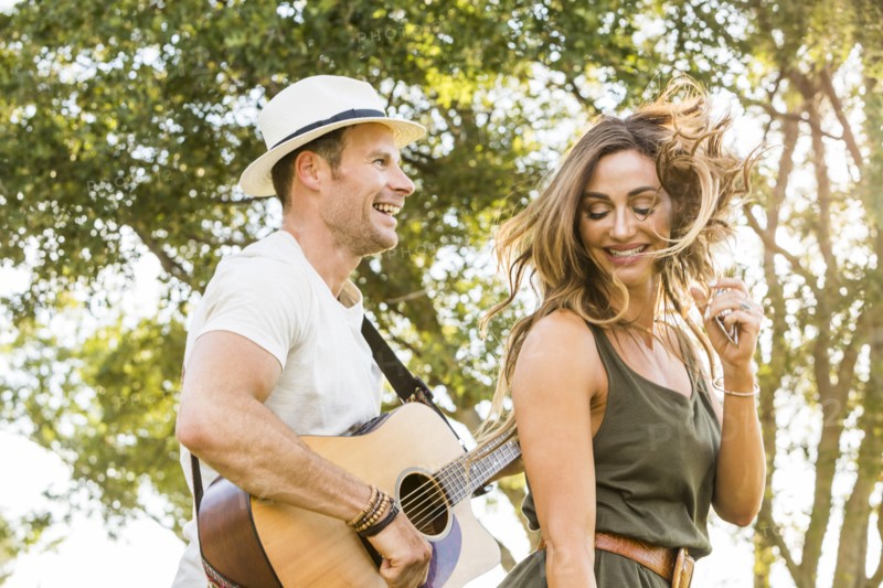 Happy woman and man having fun in park at summer