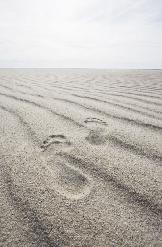 Footprints on rippled sand on beach