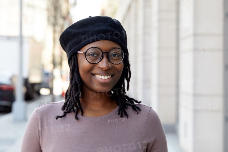 Portrait of smiling woman wearing eyeglasses and beret in city