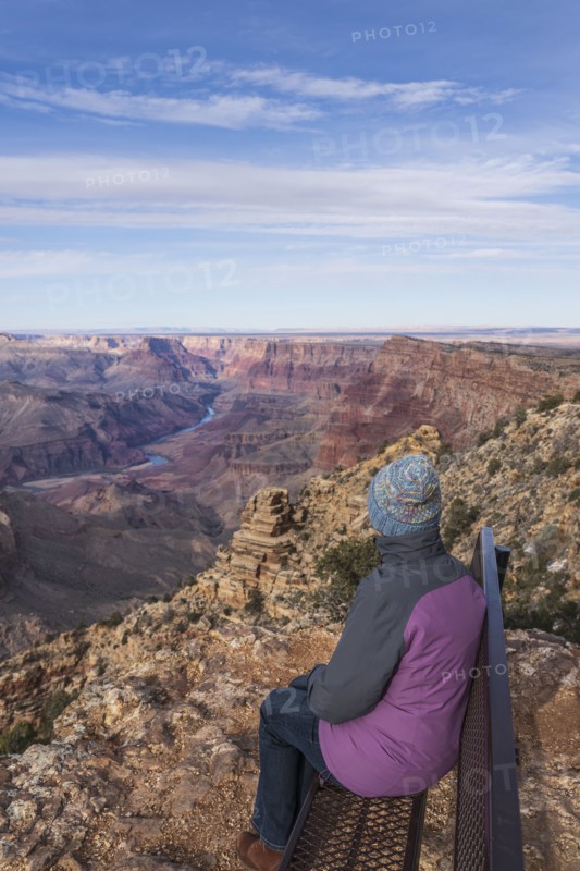 Rear view of female tourist sitting on bench in Grand Canyon National Park
