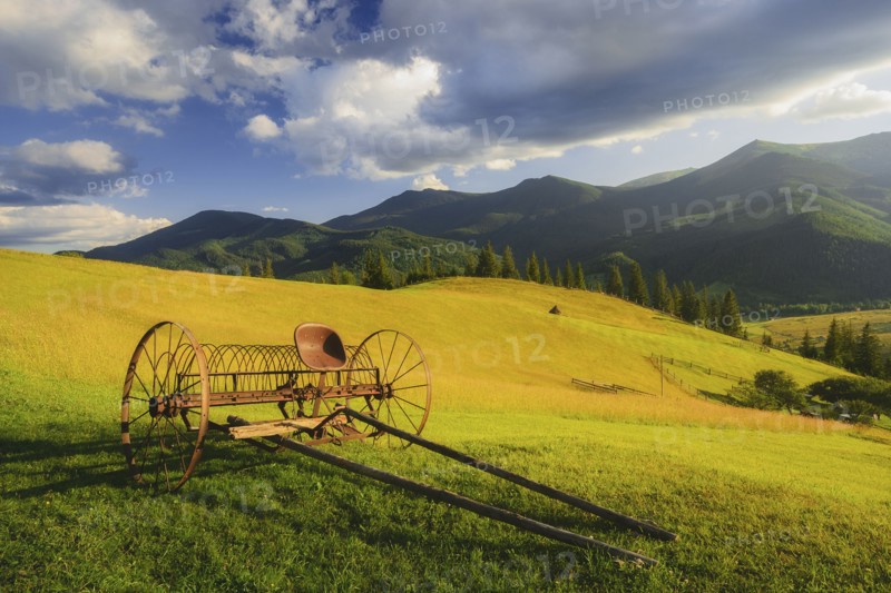 Old farm machine in rural landscape in Carpathian Mountains