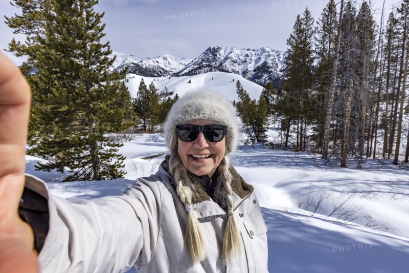 Senior woman taking selfie in snowy mountains