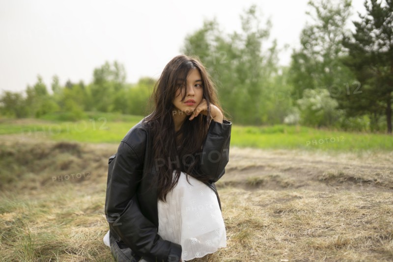 Portrait of teenage girl crouching in nature
