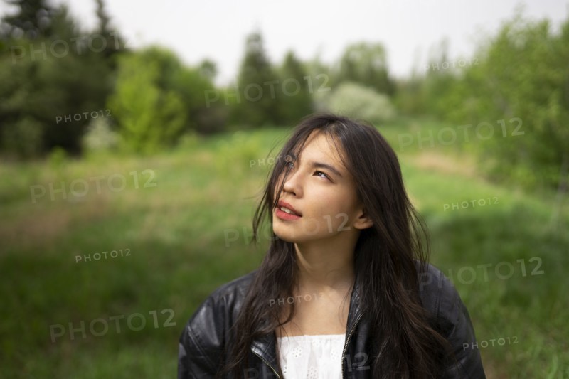 Portrait of teenage girl looking up in forest