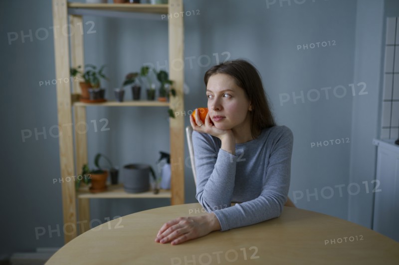 Portrait of thoughtful woman with apple in hand