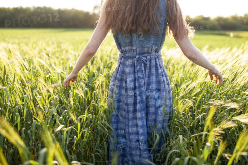Rear view of woman walking in field