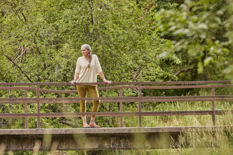 Mature woman standing on bridge in nature
