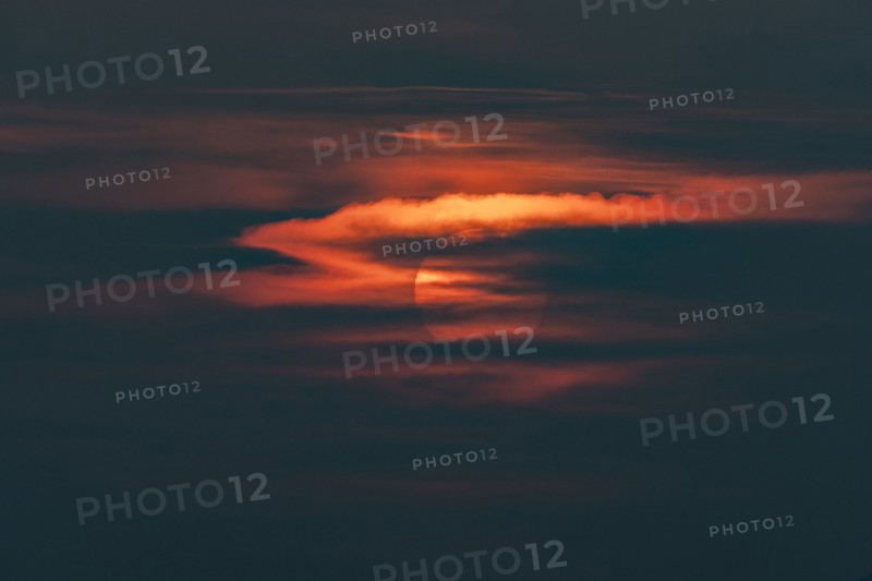 Sun behind clouds at sunset