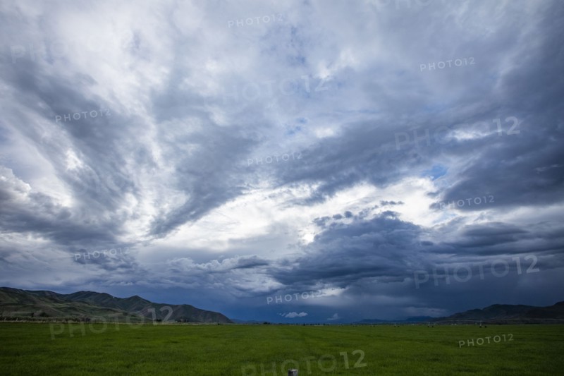 Storm clouds above landscape with meadow