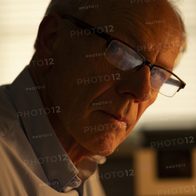 Portrait of thoughtful senior man looking at camera at home