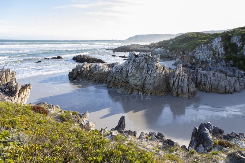 Rocky coastline with Atlantic Ocean in Voelklip Beach on sunny day