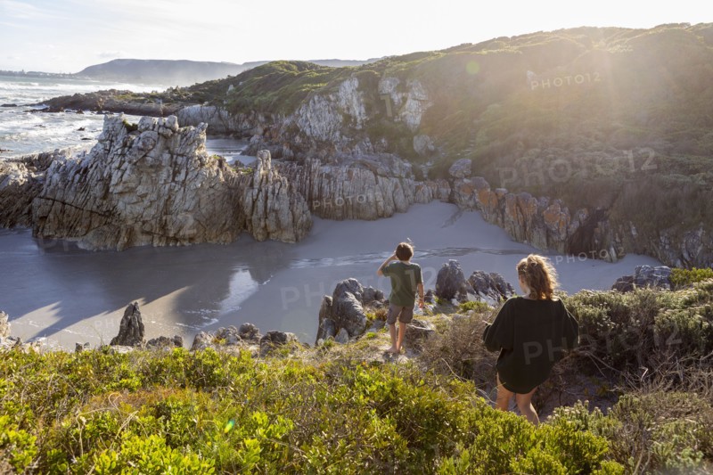 Brother and sister exploring rocky coastline in Voelklip Beach