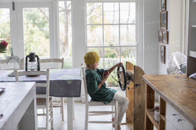 Boy pretending to drive homemade steering wheel
