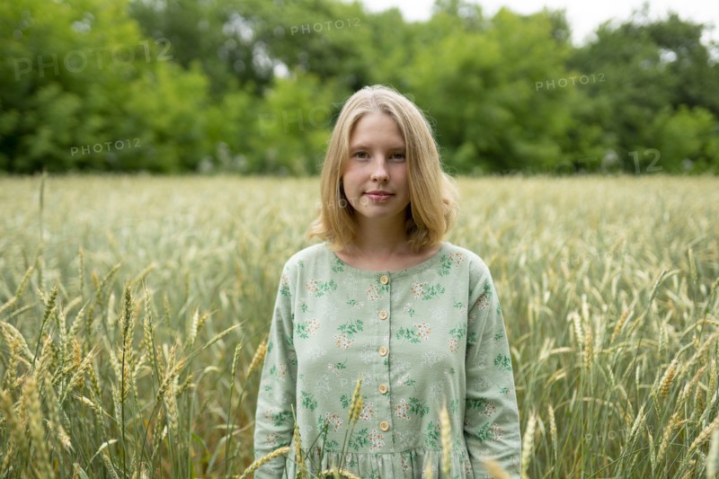 Young woman standing in wheat field in summer