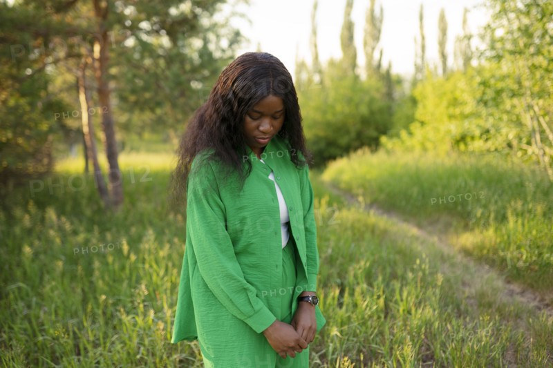 Brunette woman standing in meadow and looking down