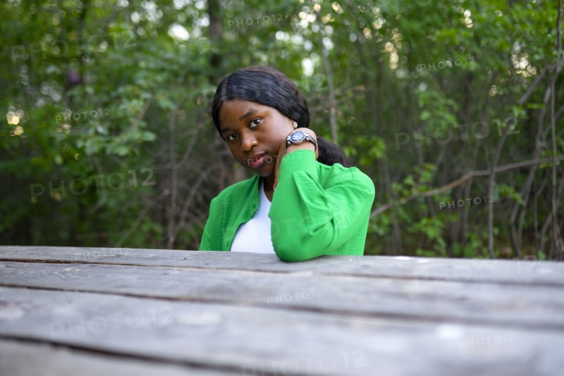 Woman looking at camera and sitting at picnic table