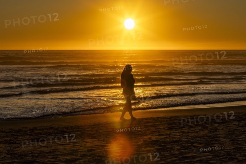Silhouette of woman walking along Cannon Beach
