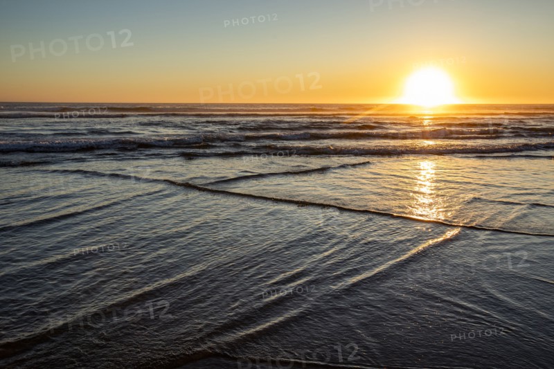 Sun setting over ocean at Cannon Beach