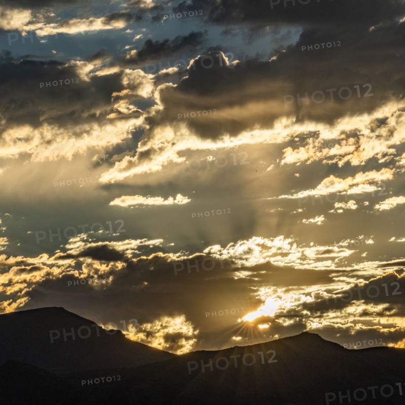 Silhouette of mountains with sunrise in background