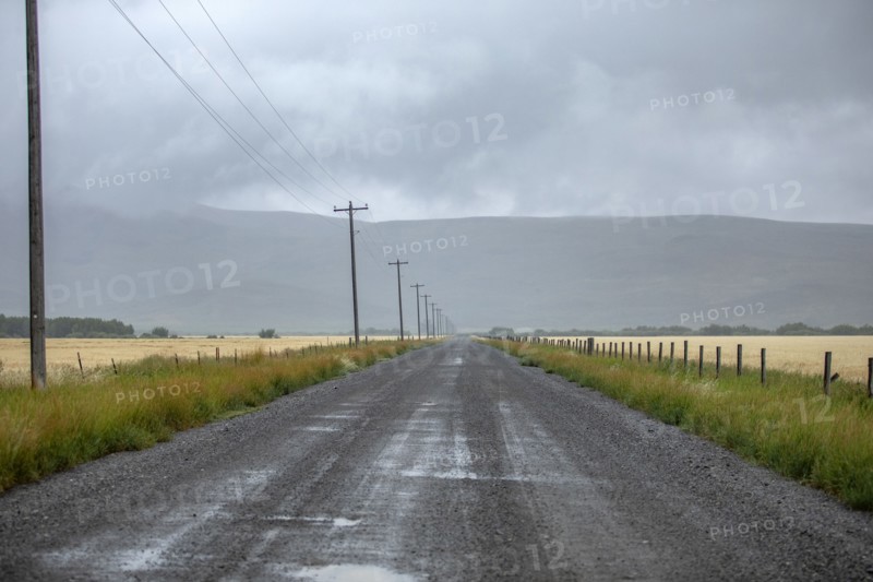 Rain clouds over dirt road in summer