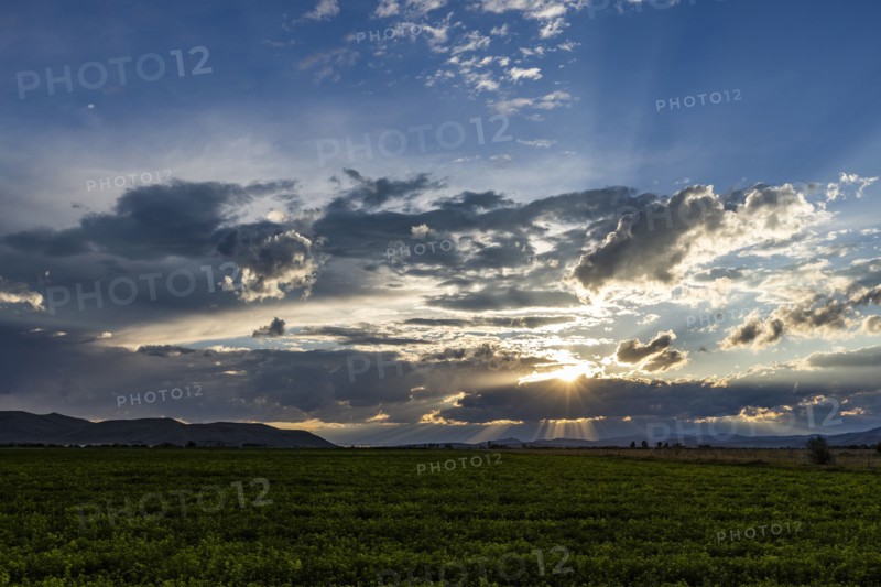 Cloudy sunset sky over rural landscape