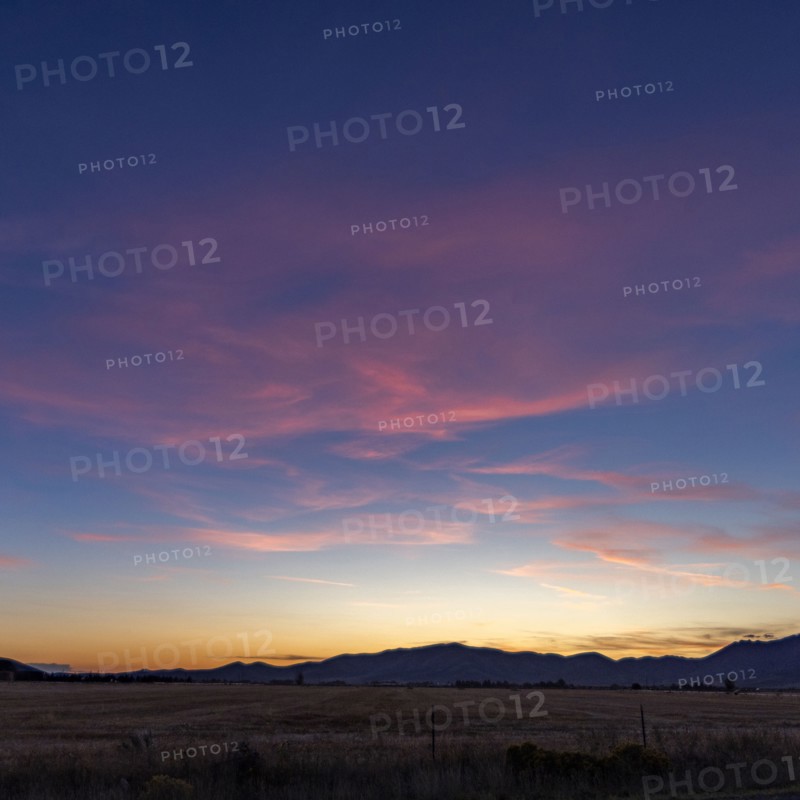 Sunset sky over agricultural fields and mountains
