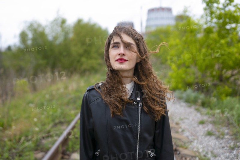 Portrait of woman standing on railroad track