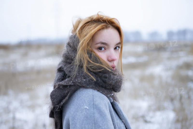 Portrait of young woman standing in snowy landscape
