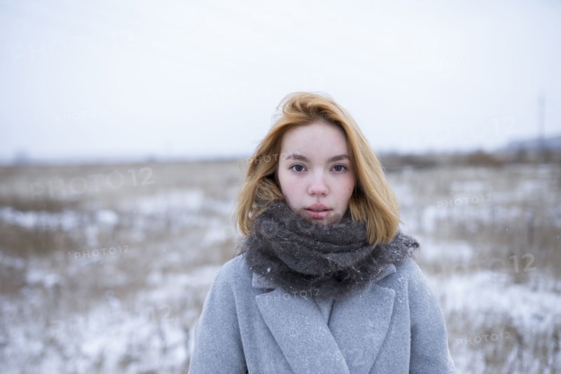 Portrait of young woman standing in snowy landscape