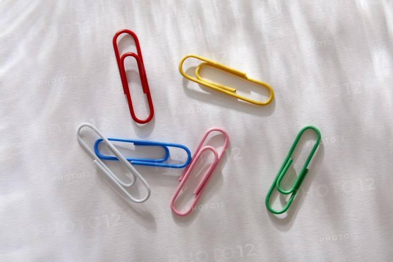 Overhead view of colorful paper clips on white background, New York, NY, USA