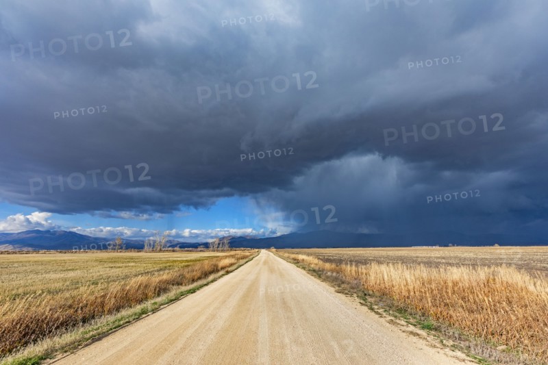 Storm clouds over empty dirt road in rural landscape, Fairfield, Idaho, USA