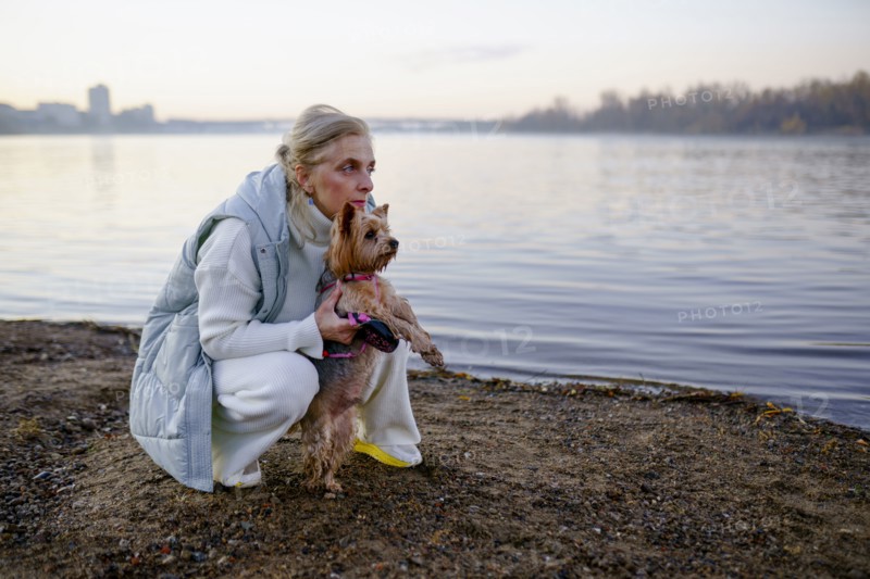 Woman with Yorkshire Terrier on lakeshore, Omsk, , Russia