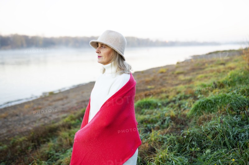 Portrait of woman wrapped in red shawl on lakeshore, Omsk, , Russia