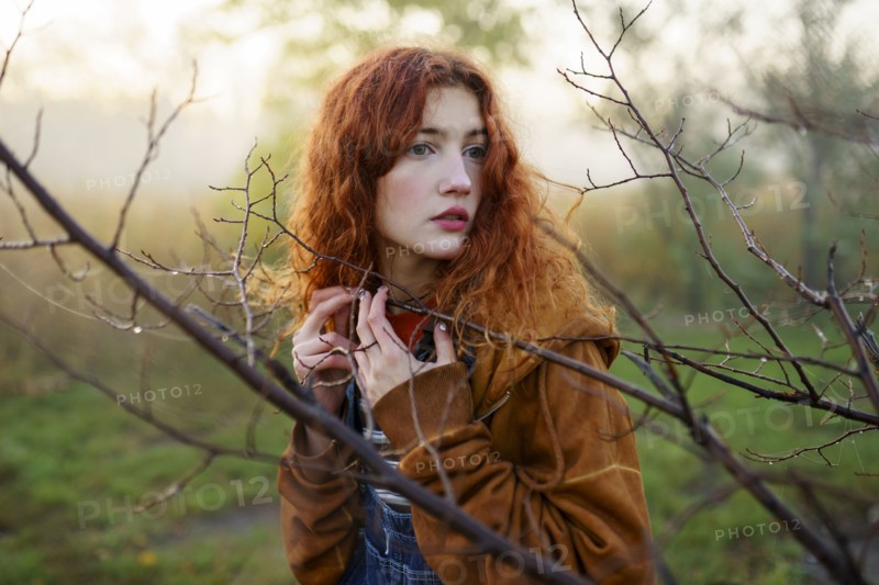 Portrait of redhead women in foggy field in autumn, Omsk, , Russia