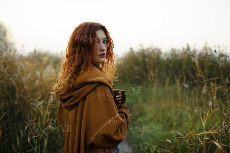 Portrait of woman with red hair standing in grassy field, Omsk, , Russia