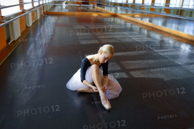 Ballerina sitting on floor in ballet studio, Omsk, , Russia