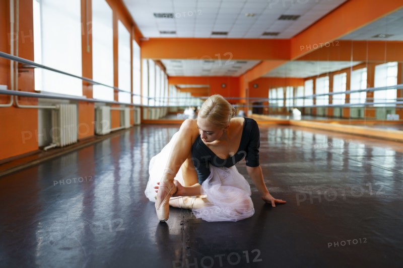 Ballerina sitting on floor in ballet studio, Omsk, , Russia