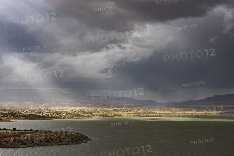Usa, New Mexico, Abiquiu, Sun shining through storm clouds over Abiquiu Lake, Abiquiu, New Mexico, USA