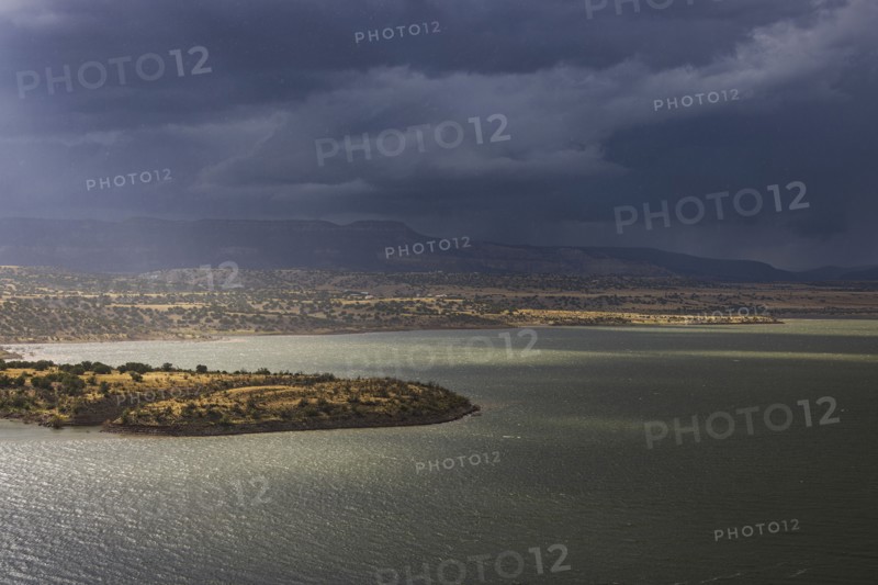 Usa, New Mexico, Abiquiu, Sun shining through storm clouds over Abiquiu Lake, Abiquiu, New Mexico, USA