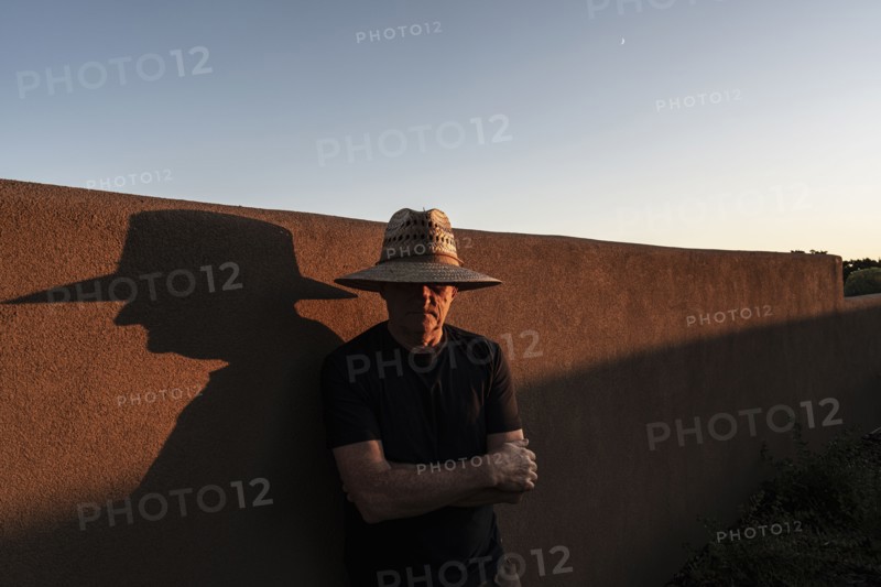 Usa, New Mexico, Santa Fe, Portrait of man in straw hat against adobe wall, Santa Fe, New Mexico, USA
