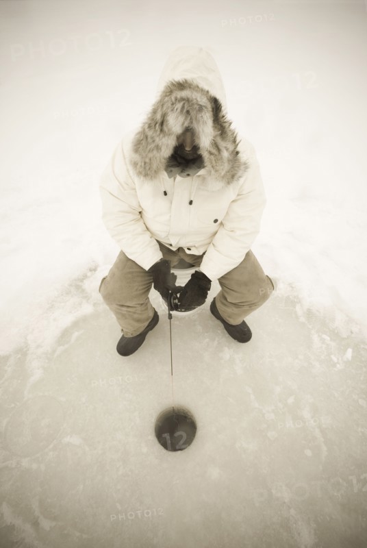 USA, NY, Hammond, High angle view of man ice fishing on frozen Black Lake, Hammond, Hammond, New York, USA