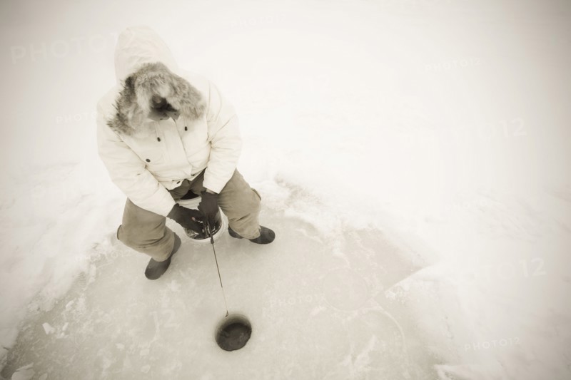 USA, NY, Hammond, High angle view of man ice fishing on frozen Black Lake, Hammond, Hammond, New York, USA
