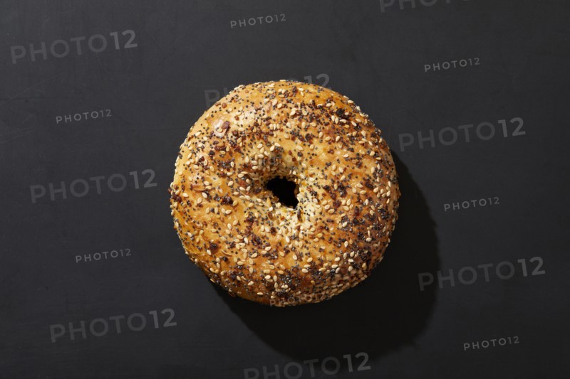 Overhead view of bagel with seeds on black background, New York, New York, USA