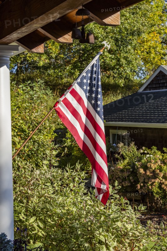 American flag outside house in sunlight, Mt. Horeb, Wisconsin, USA